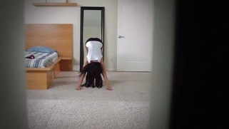 Peta Jensen in a headphones dancing nude in front of the mirror