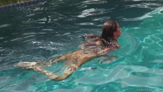 August Ames frolics in a swimming pool with her huge curves
