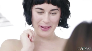 Jenna Sativa is sucking Olive Glass' strap-on