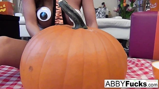 After carving a pumpkin, Abigail plays with herself.