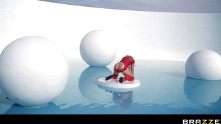Nikki Benz posing at the water park in a red latex dress